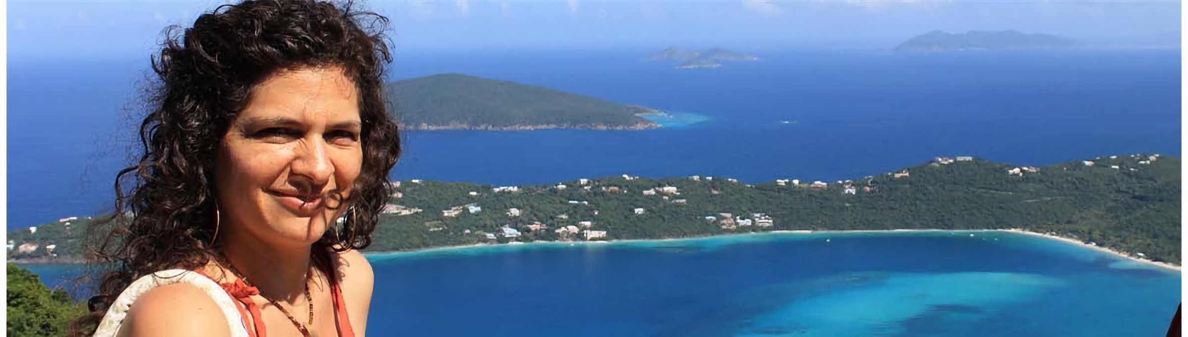 Kalyn smiling above a turquoise bay and green islands